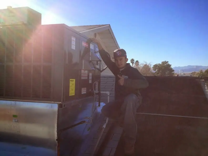 HVAC technician performing Air Duct Repair on a rooftop unit in Semmes