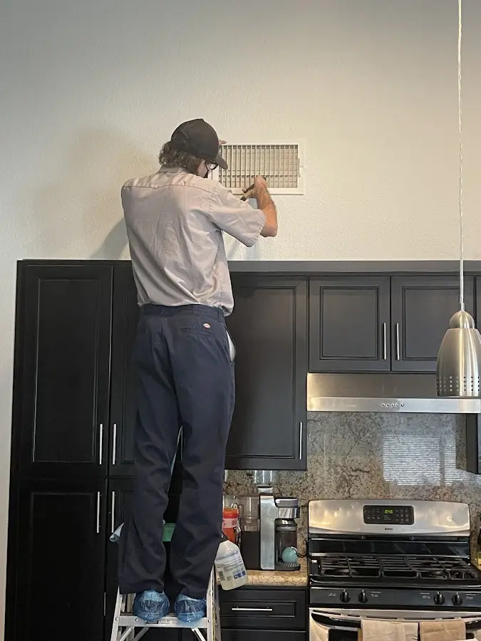 Technician inspecting an air vent during HVAC service in Semmes